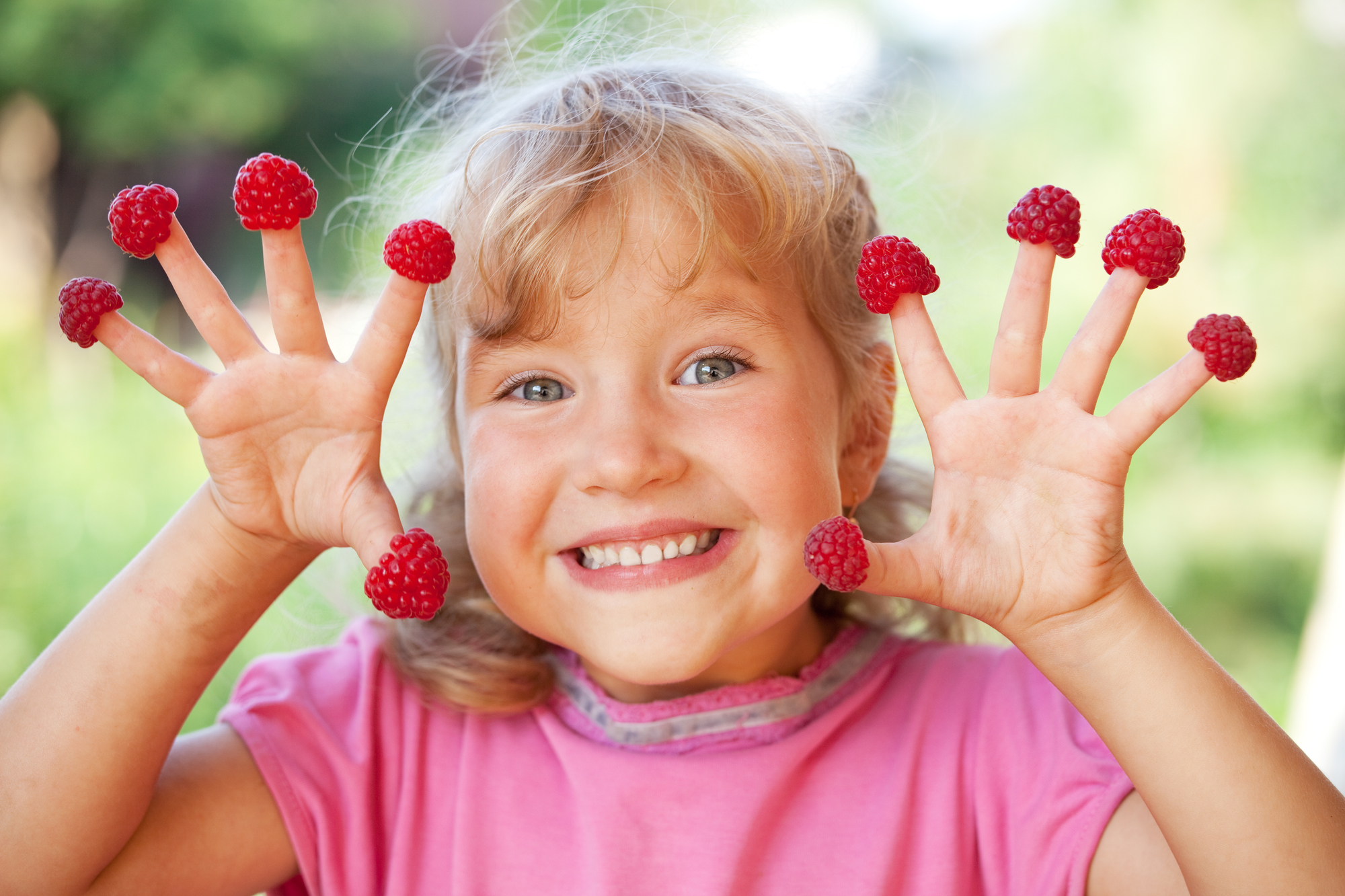 Little girl with raspberry